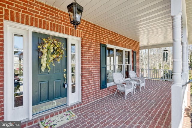 property entrance with brick siding and covered porch