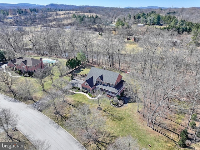 birds eye view of property featuring a forest view