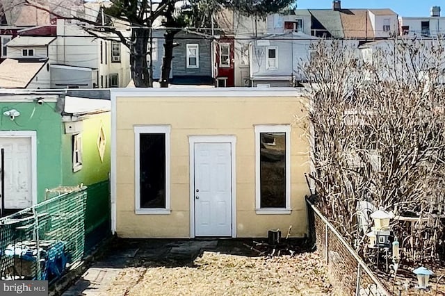 back of house featuring fence and stucco siding