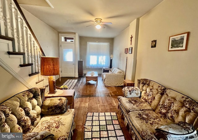 living area with stairs, ceiling fan, and wood-type flooring