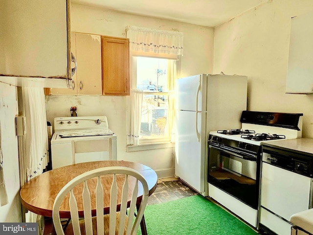 kitchen featuring baseboards, white appliances, washer / clothes dryer, and light countertops