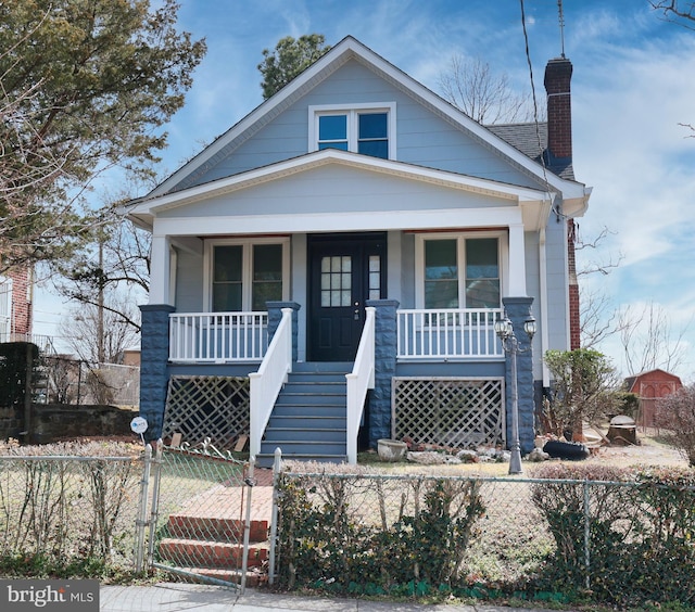 bungalow-style home with a chimney, a gate, a fenced front yard, covered porch, and stairs