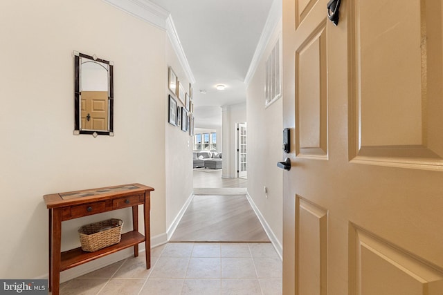 hallway with baseboards, light tile patterned flooring, and crown molding