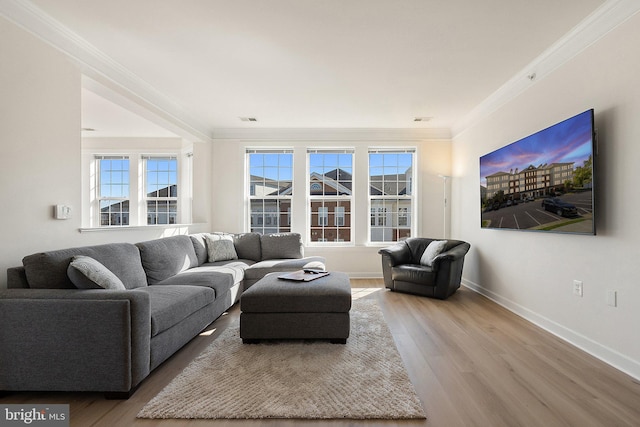 living room featuring visible vents, baseboards, wood finished floors, and ornamental molding