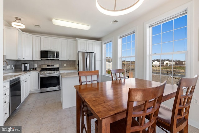 kitchen featuring backsplash, visible vents, appliances with stainless steel finishes, and a sink