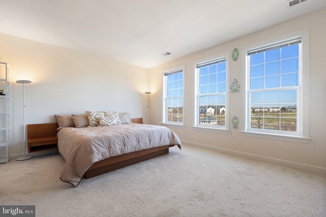 carpeted bedroom featuring visible vents and baseboards