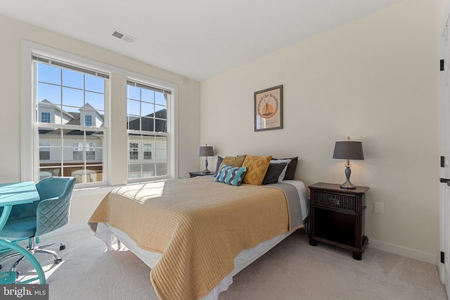 bedroom with visible vents, light colored carpet, and baseboards