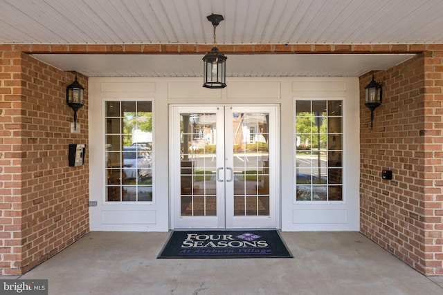 view of exterior entry with french doors and brick siding