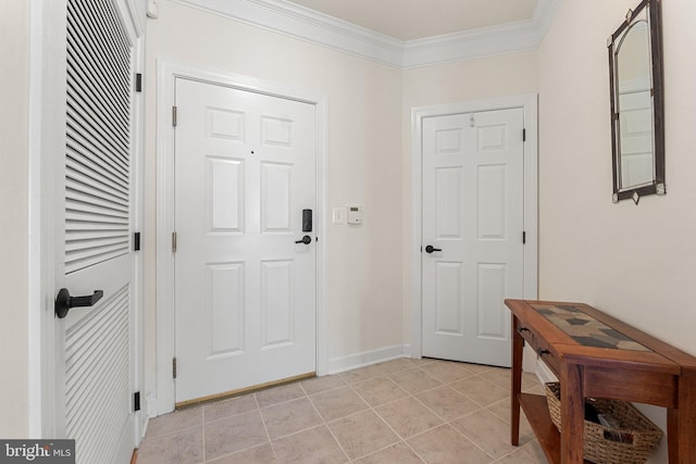 foyer entrance with light tile patterned floors, crown molding, and baseboards