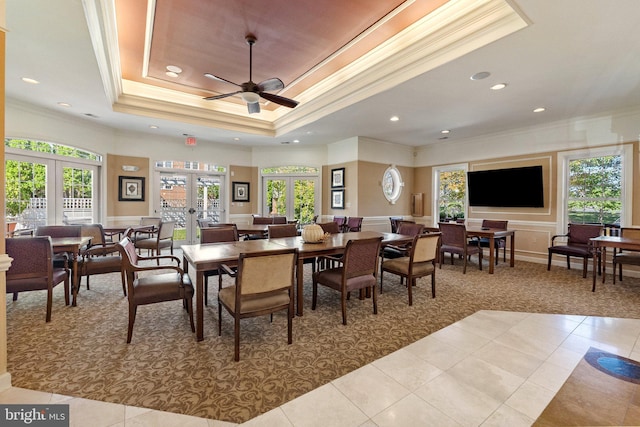 carpeted dining room featuring tile patterned flooring, a tray ceiling, ornamental molding, recessed lighting, and french doors