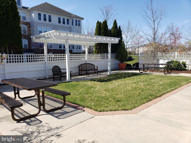 view of property's community with a yard, a patio, fence, and a pergola