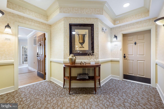 carpeted entrance foyer featuring wallpapered walls, crown molding, and baseboards