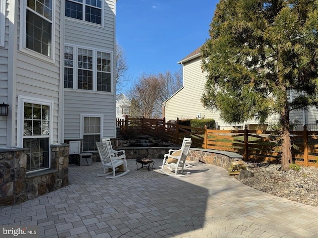 view of patio with an outdoor fire pit and fence