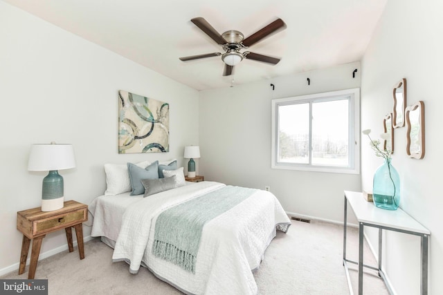 bedroom with visible vents, light colored carpet, a ceiling fan, and baseboards