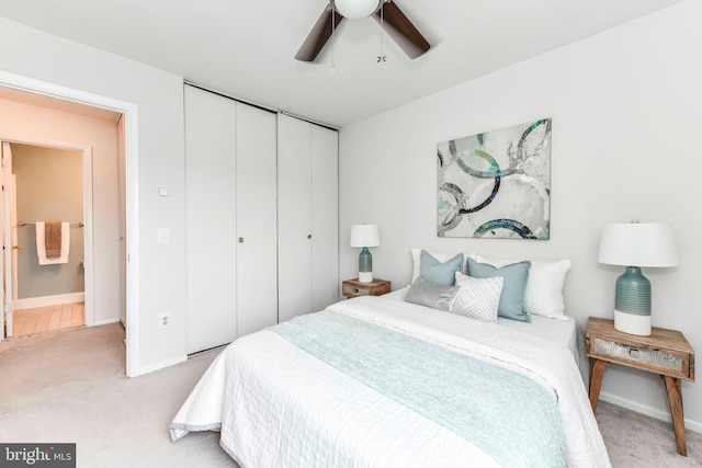 bedroom featuring a closet, light colored carpet, baseboards, and a ceiling fan