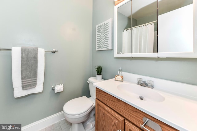 bathroom with toilet, vanity, a shower with shower curtain, and baseboards