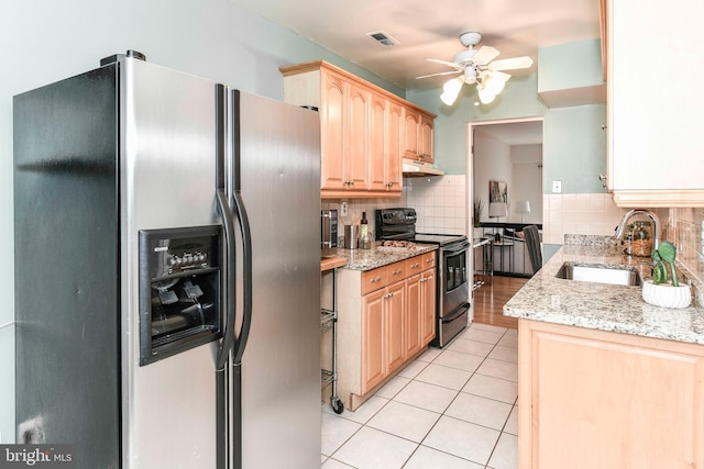 kitchen featuring light brown cabinets, electric range, a sink, under cabinet range hood, and stainless steel fridge