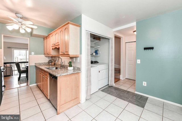 kitchen featuring washing machine and clothes dryer, a sink, light brown cabinetry, light tile patterned floors, and stainless steel dishwasher