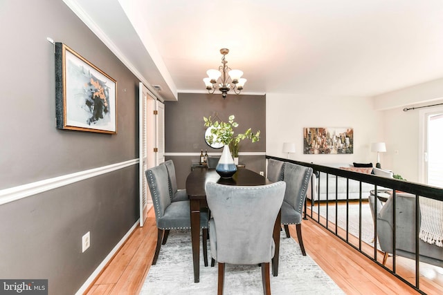 dining space featuring a notable chandelier, stairs, and wood finished floors