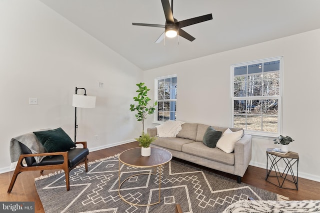 living area with baseboards, wood finished floors, ceiling fan, and vaulted ceiling