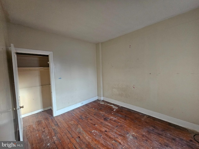 unfurnished bedroom with a closet, baseboards, and wood-type flooring