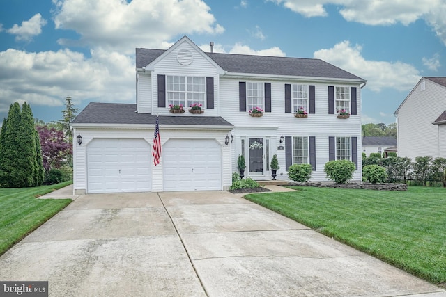 view of front of house with an attached garage, concrete driveway, and a front yard