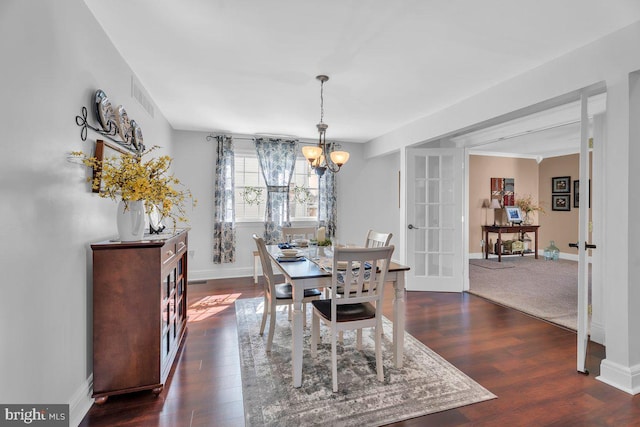 dining room with baseboards, visible vents, dark wood finished floors, french doors, and a chandelier