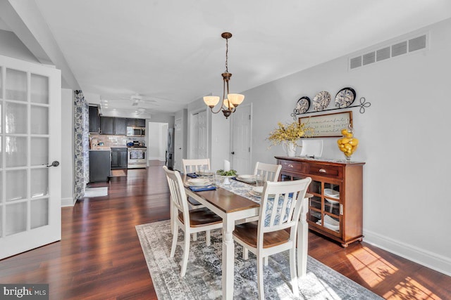 dining area with a chandelier, visible vents, dark wood-type flooring, and baseboards