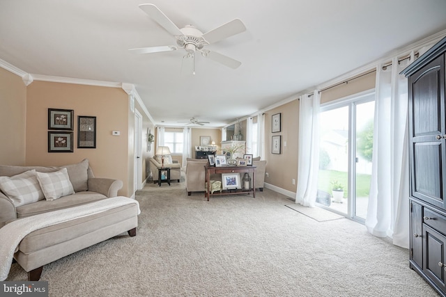 living room featuring light carpet, a ceiling fan, crown molding, and baseboards