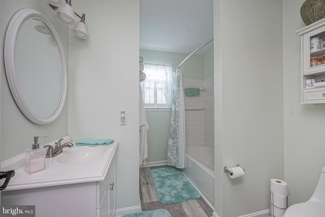 bathroom featuring toilet, vanity, baseboards, and wood finished floors