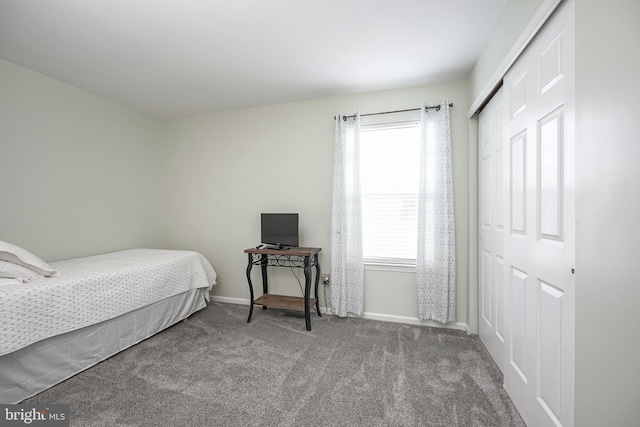 carpeted bedroom featuring a closet and baseboards