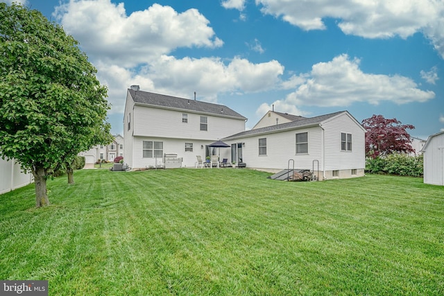 back of property featuring a lawn and fence