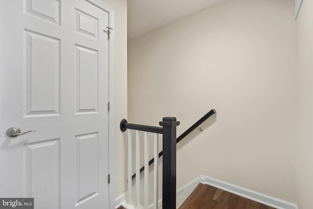 staircase featuring baseboards and wood finished floors