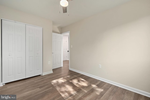 unfurnished bedroom featuring a closet, a ceiling fan, baseboards, and wood finished floors