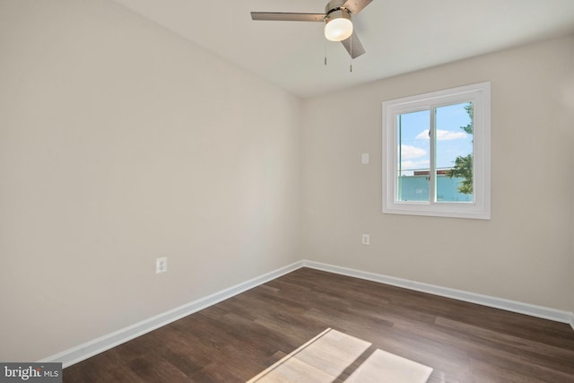 unfurnished room with a ceiling fan, baseboards, and dark wood-style flooring