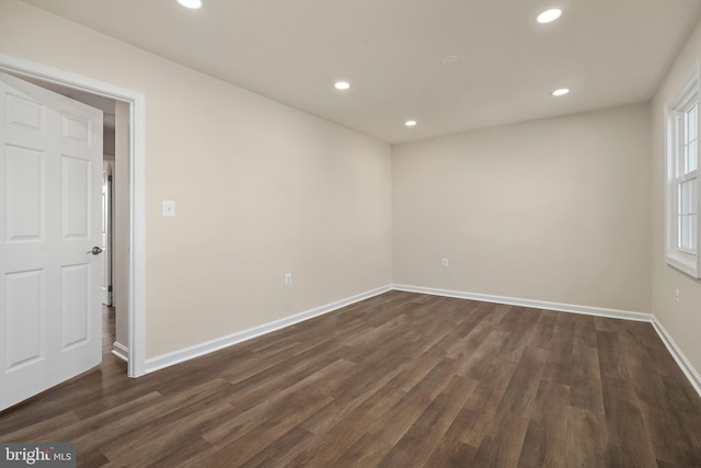 spare room featuring recessed lighting, baseboards, and dark wood finished floors