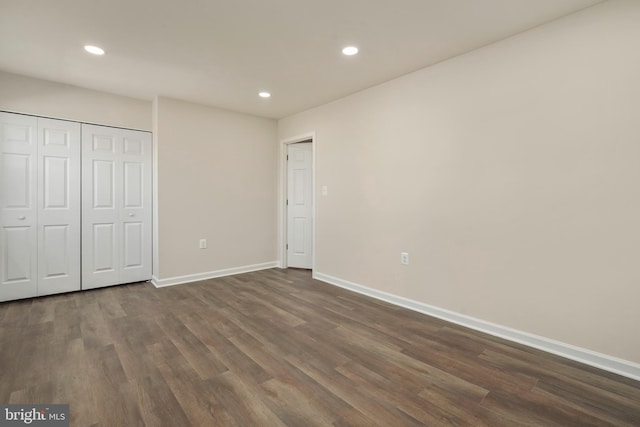 unfurnished bedroom featuring dark wood-type flooring, recessed lighting, baseboards, and a closet