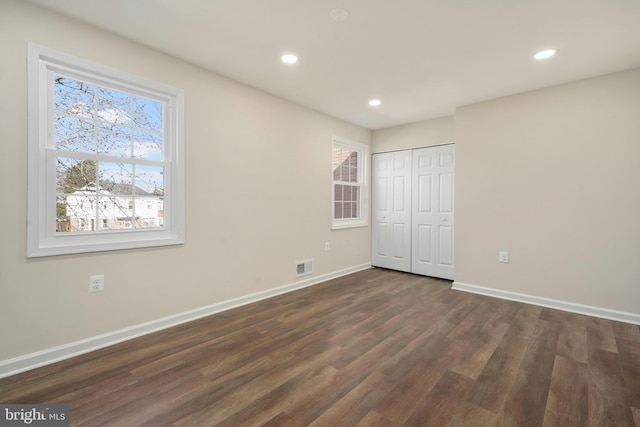 unfurnished bedroom featuring visible vents, baseboards, dark wood finished floors, recessed lighting, and a closet