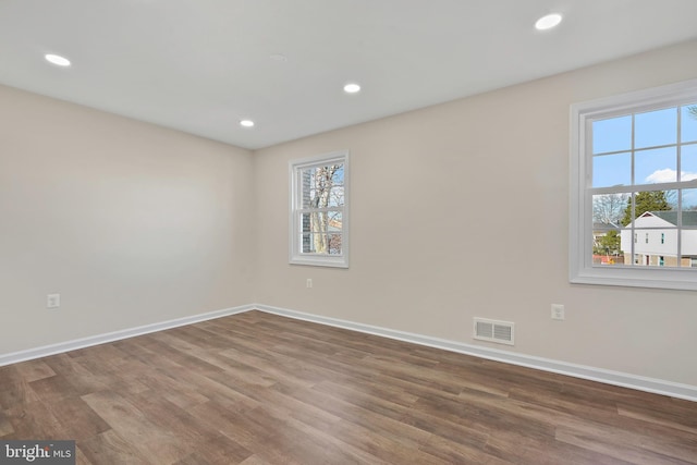 empty room featuring recessed lighting, baseboards, and wood finished floors