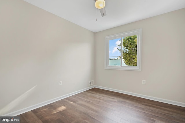 empty room featuring visible vents, baseboards, and wood finished floors