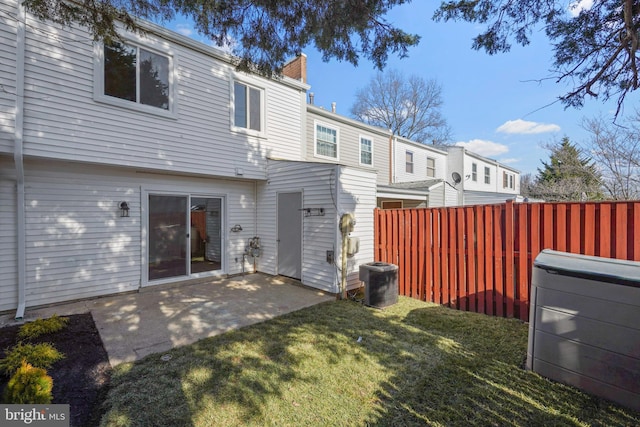 rear view of property with a patio area, fence, a lawn, and a chimney