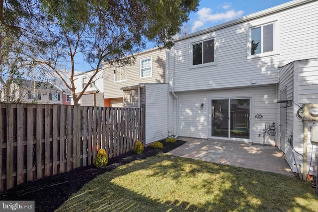 rear view of house with a yard, a patio, and a fenced backyard