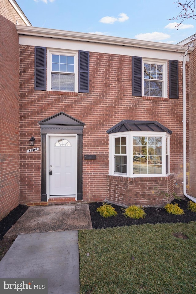 view of front of house featuring brick siding and a front yard