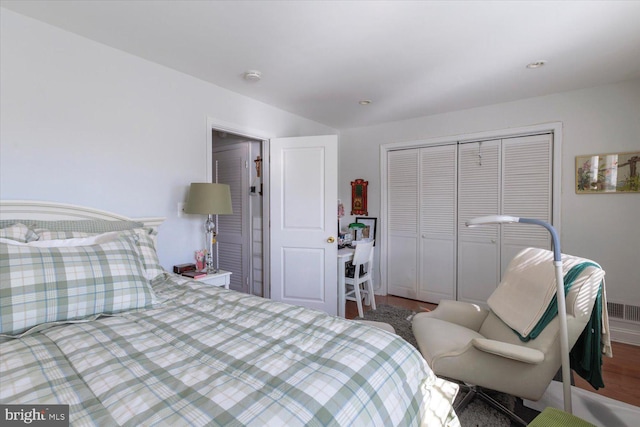 bedroom featuring a closet, visible vents, and wood finished floors