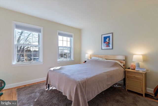 bedroom featuring baseboards and wood finished floors