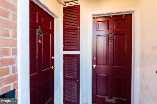 view of exterior entry featuring brick siding and stucco siding