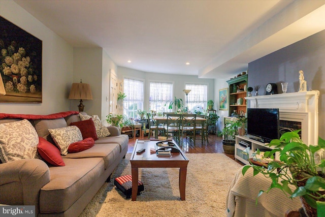 living room featuring recessed lighting, a fireplace, and wood finished floors