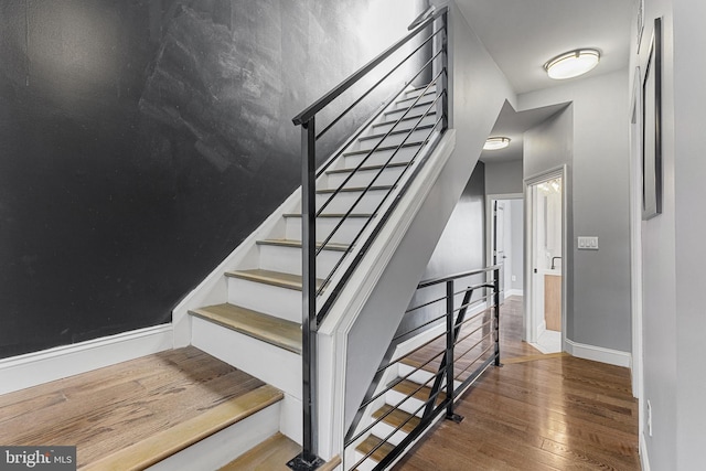 staircase featuring hardwood / wood-style flooring and baseboards