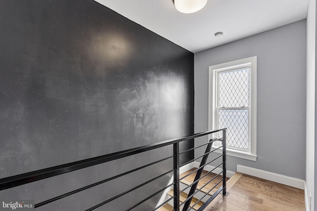 staircase featuring baseboards and wood finished floors