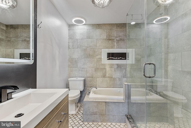 bathroom with a garden tub, vanity, toilet, and a shower stall